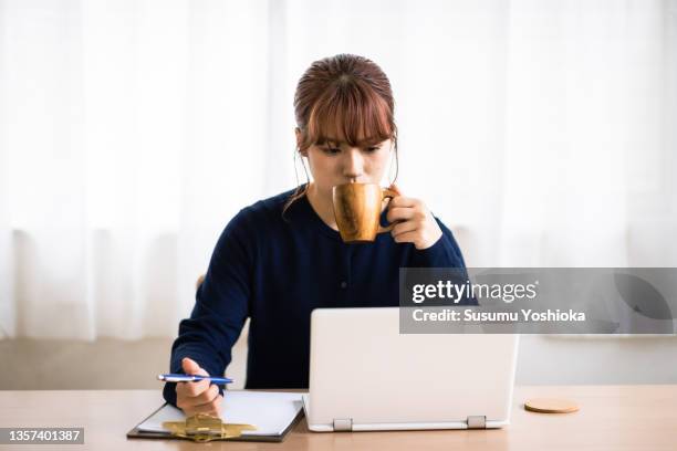 a woman working on a computer at home. - 茅ヶ崎市 fotografías e imágenes de stock