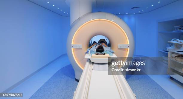 male patient being slide into mri scanner - mri scanner stock pictures, royalty-free photos & images