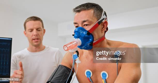 man taking a cardiopulmonary stress test in clinic - cardiopulmonary system stock pictures, royalty-free photos & images