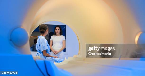 femme parlant avec un médecin avant l’irm - hospital gown stock photos et images de collection
