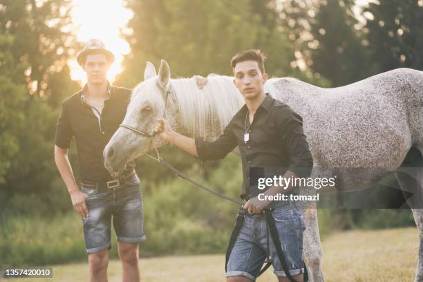 amici maschi che camminano a cavallo - horse and male and riding foto e immagini stock