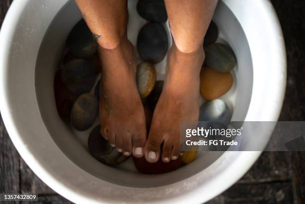 pies de una mujer joven haciendo terapia de pies en un spa - terapia lastone fotografías e imágenes de stock