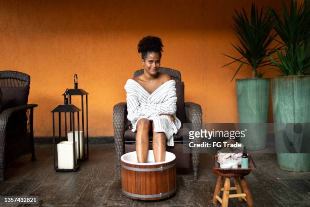 portrait of a young woman doing a foot treatment at a spa - african ethnicity spa stock pictures, royalty-free photos & images