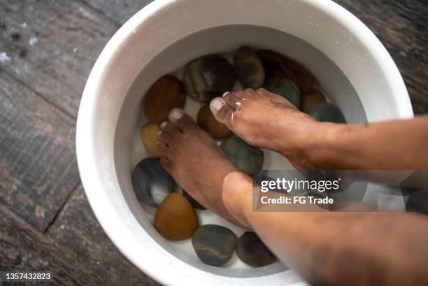 feet of a young woman doing foot therapy at a spa - foot spa stock pictures, royalty-free photos & images