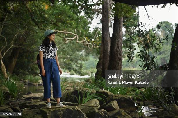 woman walking through rocks in a forest - coorg india stock pictures, royalty-free photos & images