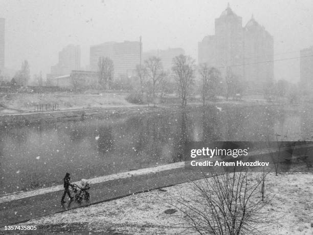 figure of human with baby carriage walking during hard blizzard - dnieper river stock pictures, royalty-free photos & images