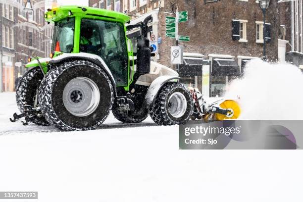 tractor clearing the streets of snow with a snow plow and brush - snow blower stock pictures, royalty-free photos & images