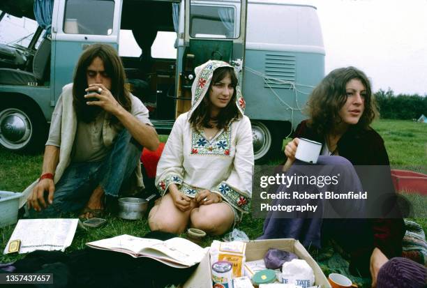 Group of festival goers drinking tea beside a VW camper van at the first Glastonbury Festival, United Kingdom, September 1970.