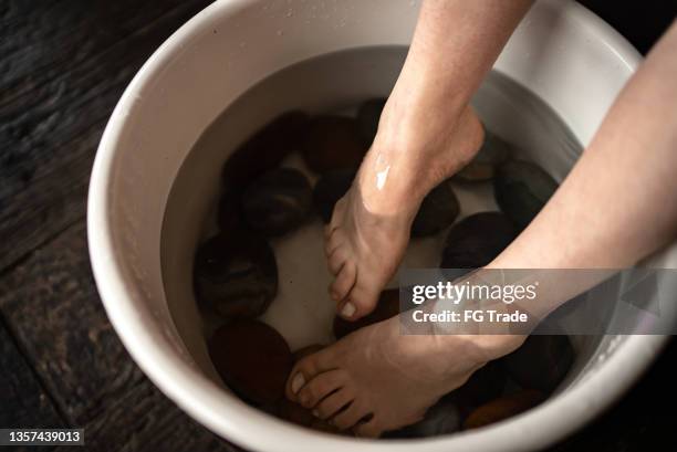 feet of an adult woman doing foot therapy at a spa - drenched stock pictures, royalty-free photos & images