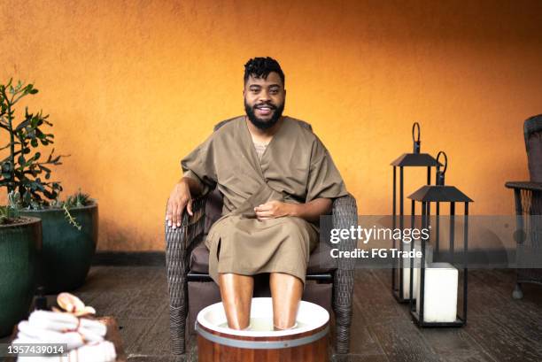 portrait of a mid adult man doing a foot treatment at a spa - beautiful male feet stock pictures, royalty-free photos & images