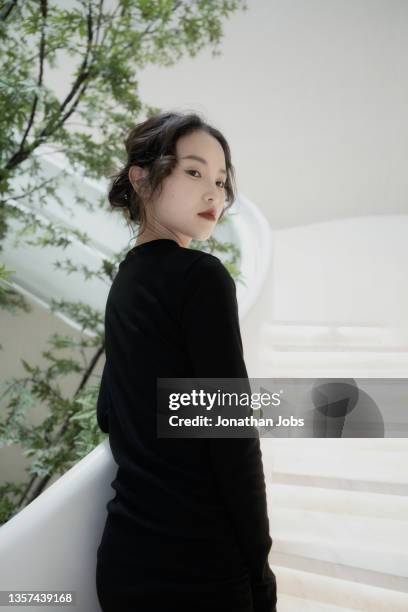 in the empty simple bright spiral staircase wearing black skirt asian girl - fashionable asian stock pictures, royalty-free photos & images