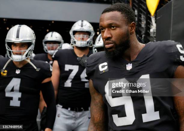 Quarterback Derek Carr, offensive tackle Kolton Miller and defensive end Yannick Ngakoue of the Las Vegas Raiders wait to take the field for a game...