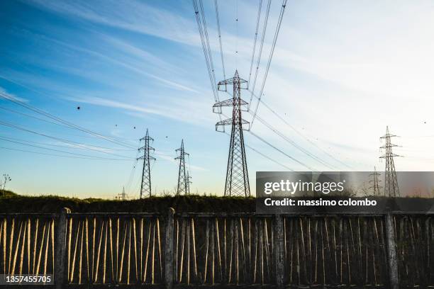 power lines electricity pylon at twilight - green economy foto e immagini stock