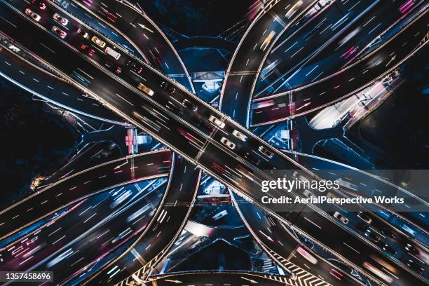 drone point view of overpass and city traffic at night - illuminated building stock pictures, royalty-free photos & images