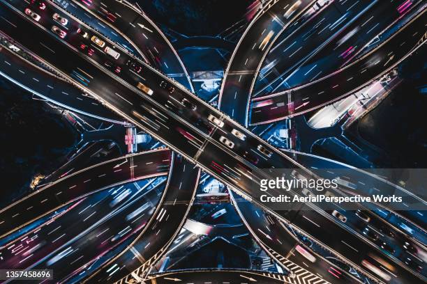 drone point view of overpass and city traffic at night - motorväg bildbanksfoton och bilder