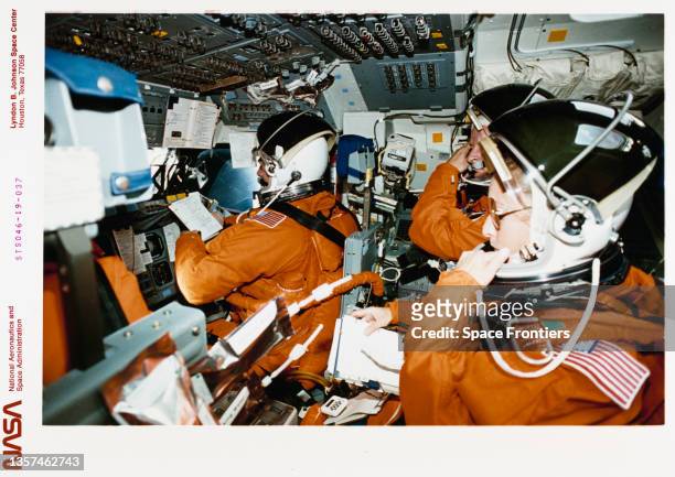 American NASA astronaut Andrew M Allen, Swiss ESA astronaut Claude Nicollier, and American NASA astronaut Marsha Ivins, each wearing launch-and-entry...