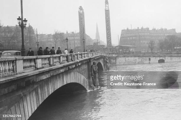 Le zouave du pont de l'Alma avec les pieds dans l'eau lors d'une crue de la Seine, le en février 1937, à Paris.