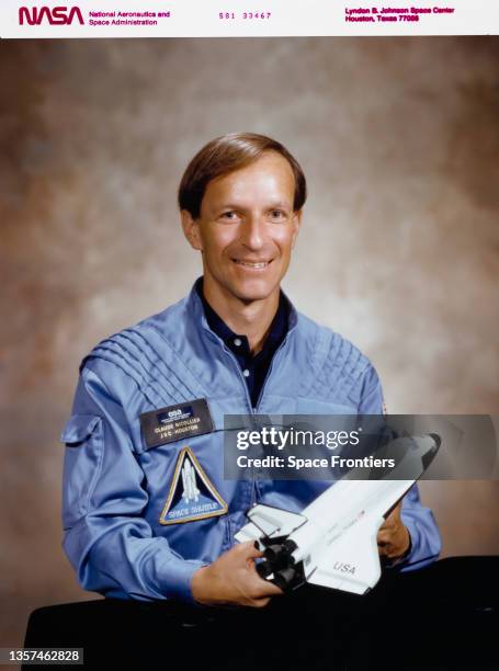 Swiss ESA astronaut Claude Nicollier, wearing a light blue flight suit while holding a model of an space shuttle, at the Johnson Space Center in...