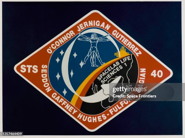 The mission insignia for STS-40 depicts the Space Shuttle Columbia in flight with the surnames of the crew around the edge of the diamond-shaped...