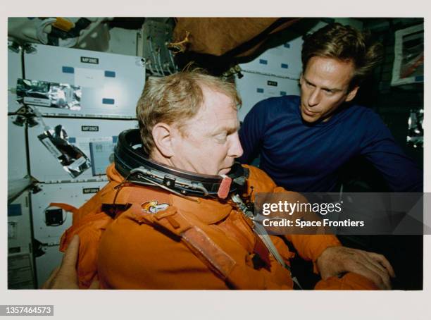 American NASA astronaut David M Walker assisted by American NASA astronaut Michael L Gernhardt as he prepares his partial-pressure launch and entry...