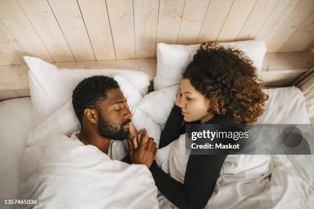 directly above view of couple sleeping on bed in hotel - couple on bed stockfoto's en -beelden
