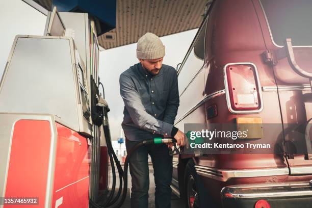 mature man filling fuel in motor home at gas station - refueling stock-fotos und bilder