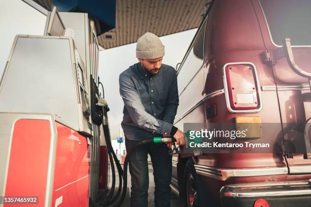 mature man filling fuel in motor home at gas station - ガソリンスタンド ストックフォトと画像