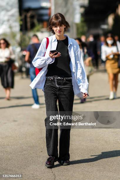 Guest wears a black tank-top, a baby blue and white striped shirt, a red shiny leather with GG monogram print pattern shoulder bag from Gucci, a...