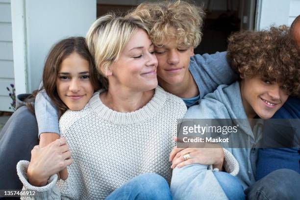 smiling mother with daughter and sons siting together - mature woman and son imagens e fotografias de stock