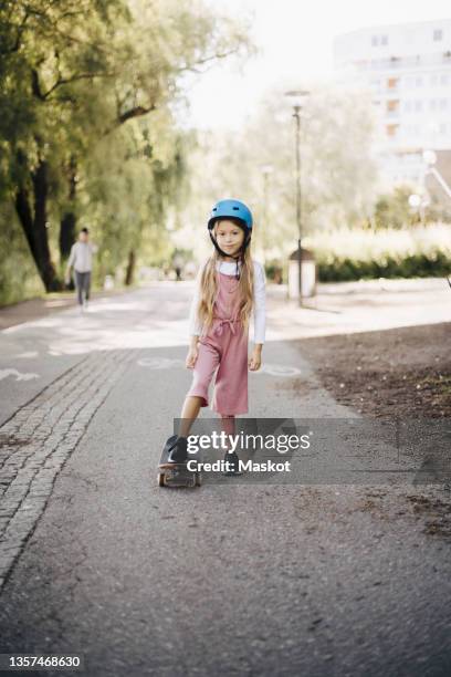 girl skateboarding on road at park - amputee girl stock pictures, royalty-free photos & images