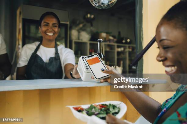 happy female customer doing contactless payment at food truck - contactless payment 個照片及圖片檔