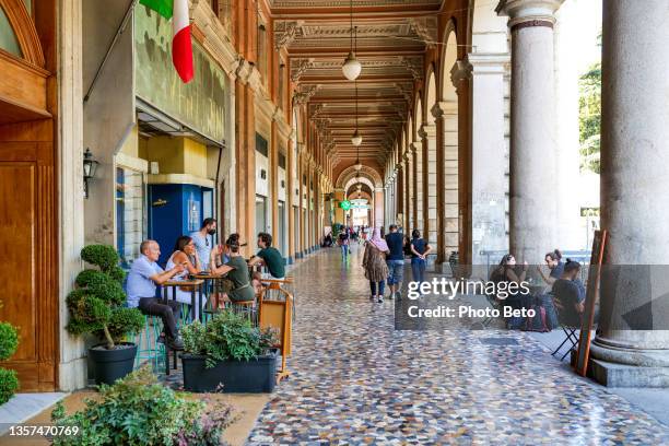 pedoni e clienti sotto gli ampi portici di piazza vittorio nel cuore storico di roma - piazza foto e immagini stock