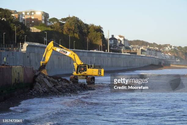 digue de défense côtière en construction à dawlish - digging beach photos et images de collection
