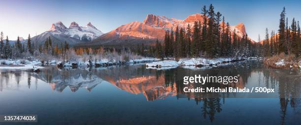 the three sisters,scenic view of lake by snowcapped mountains against sky,canmore,alberta,canada - canmore stock pictures, royalty-free photos & images