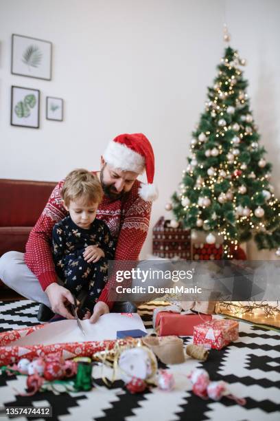 family moments at christmastime at home - santa hat stock pictures, royalty-free photos & images