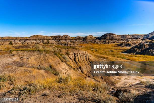 albertas incredible badlands,scenic view of landscape against clear blue sky,drumheller,alberta,canada - alberta badlands stock pictures, royalty-free photos & images