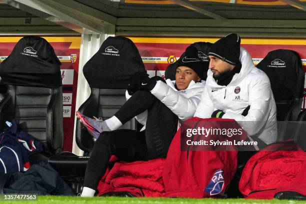 Kylian Mbappe of Paris SG and Gianluigi Donnarumma of Paris SG look on from the substitute bench during the Ligue 1 Uber Eats match between RC Lens...