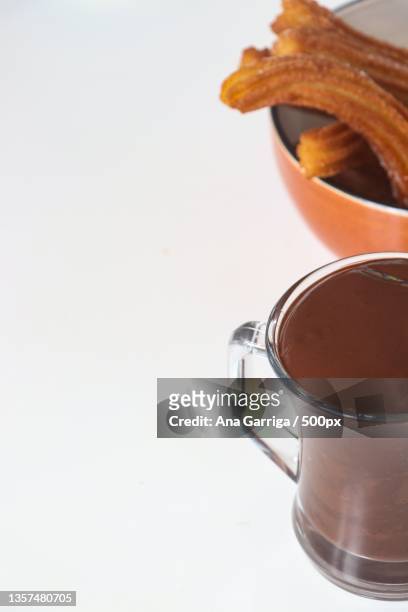 churros con chocolate,close-up of coffee cup against white background - chocolate con churros stock-fotos und bilder