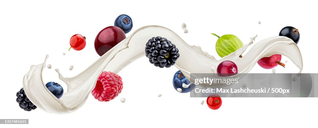 Wild berries with milk splash isolated on white background