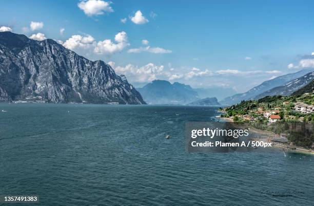 lago di garda,scenic view of sea and mountains against sky,riva del garda,trento,italy - riva del lago stock-fotos und bilder