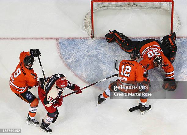 Daniar Dshunussow , goaltender of Wolfsburg makes a save on Andreas Morcinietz of Hannover during the DEL match between Hannover Scorpions and...