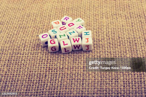 dice-sized alphabet cubes on textured surface,high angle view of text on table - table font view stock pictures, royalty-free photos & images