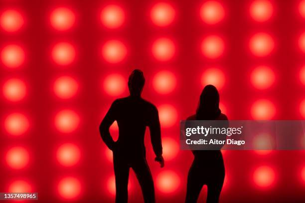 silhouette of a man and a woman with christmas lights in the background. - abstract geometric silhouette woman stock pictures, royalty-free photos & images