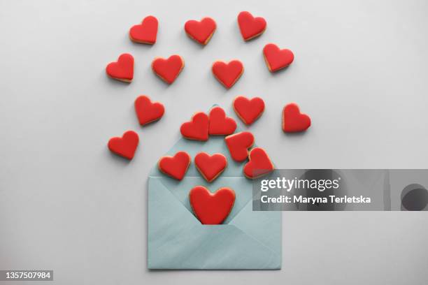 a blue envelope and a red heart shaped cookie. - candy hearts fotografías e imágenes de stock