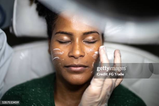 young woman doing a facial treatment at a spa - schoonheidsspecialist stockfoto's en -beelden