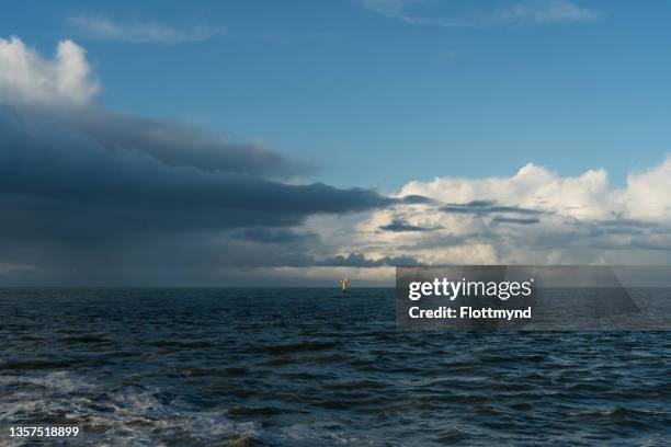 small yellow buoy in the north sea just outside the dutch coastline - north holland stock-fotos und bilder