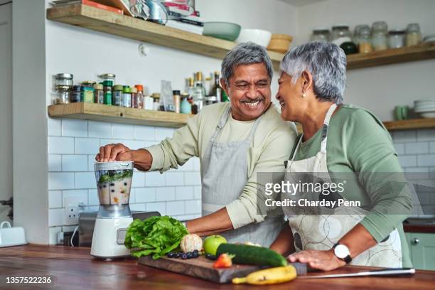 自宅の台所で健康的なスムージーを準備する先輩カップルのショット - ヘルシー ストックフォトと画像