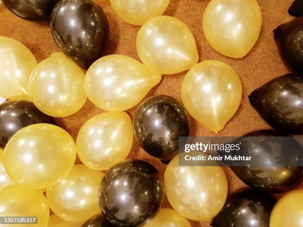 celebration golden yellow and black balloons. - black balloons stock pictures, royalty-free photos & images