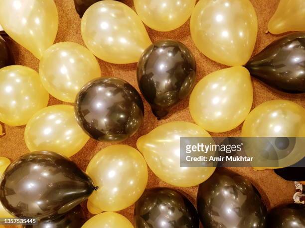 celebration golden yellow and black balloons. - black balloons stock pictures, royalty-free photos & images