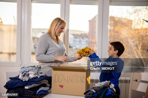 mother and son preparing donation - showing empathy stock pictures, royalty-free photos & images